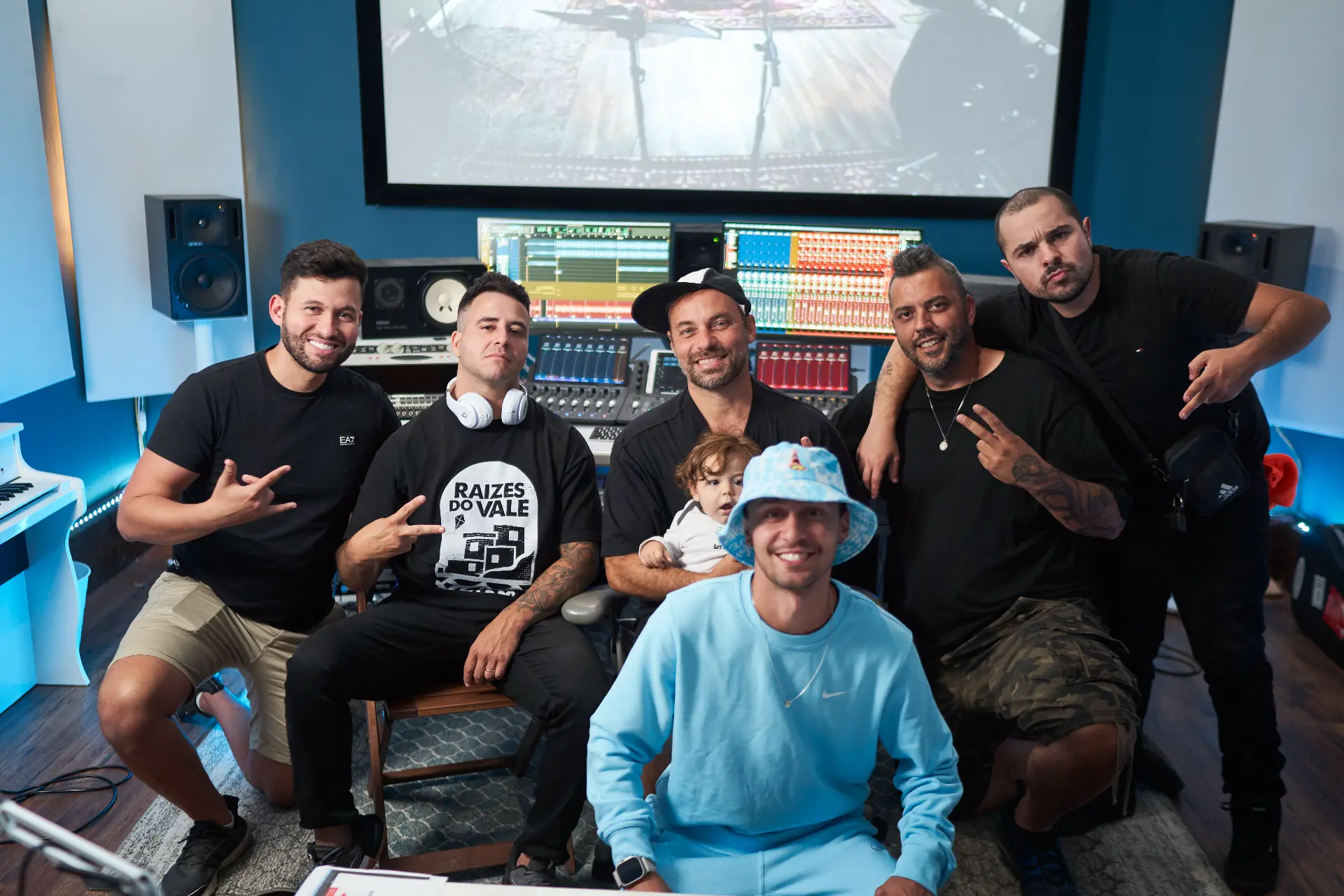 Artists gathered together smiling in the studio control room